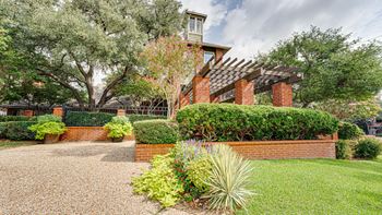 A house with a gravel driveway and a brick wall.